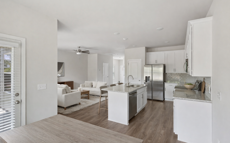 a kitchen space with an island next to sofas in the living room