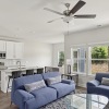 living room with sofa and white kitchen with stainless appliances